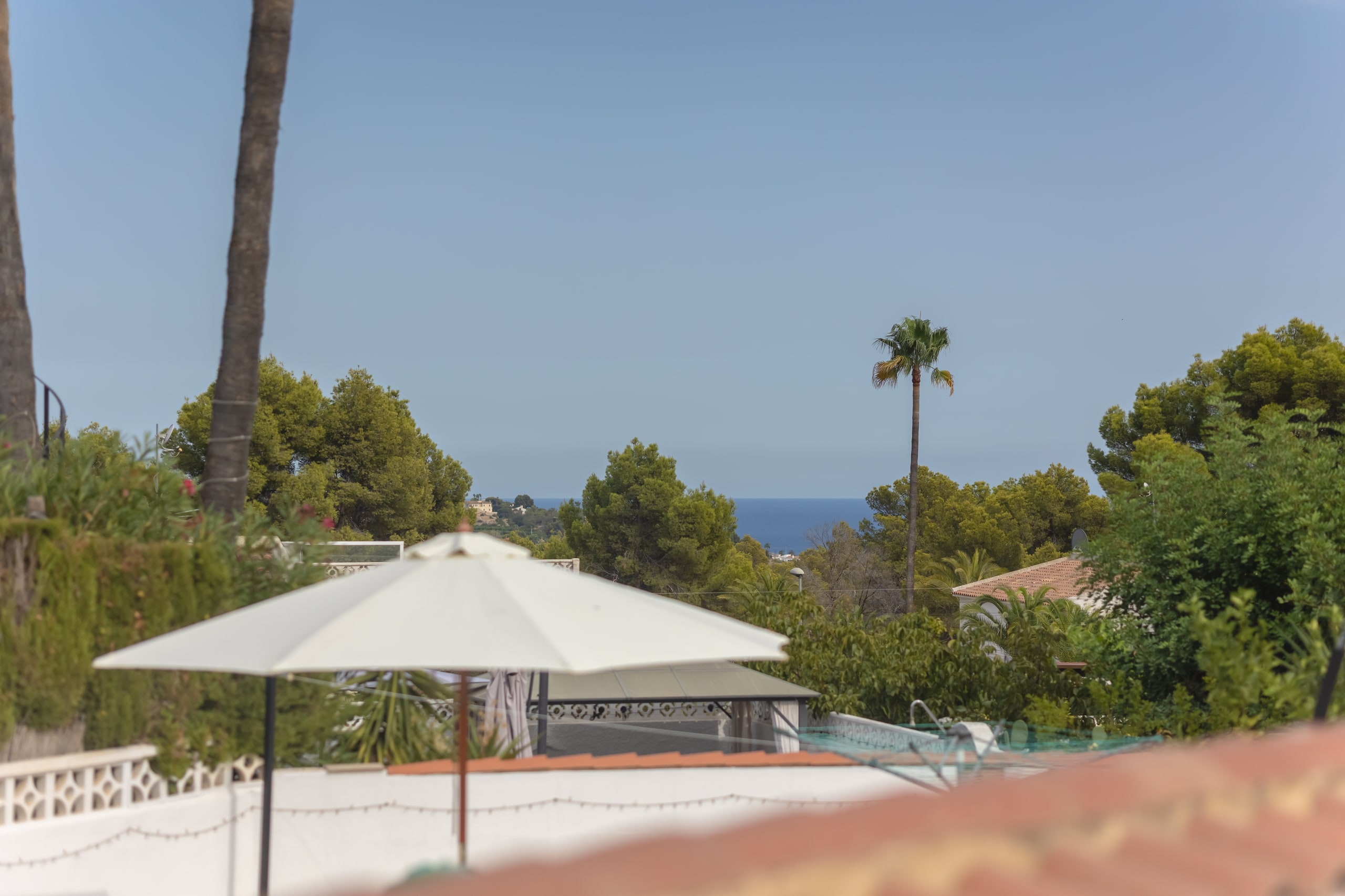 From the dining room, the sea beyond the terrace umbrellas