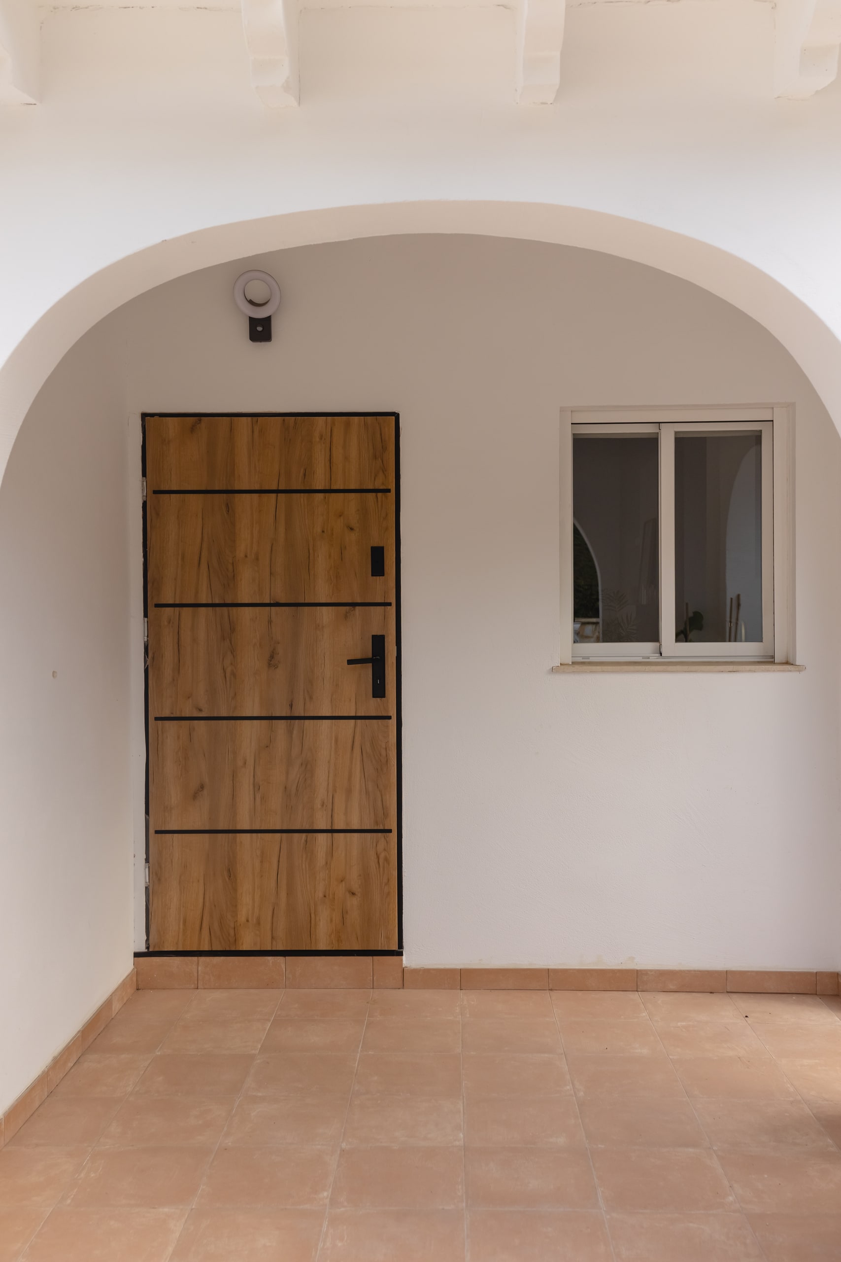 Wood front door under the arched porch