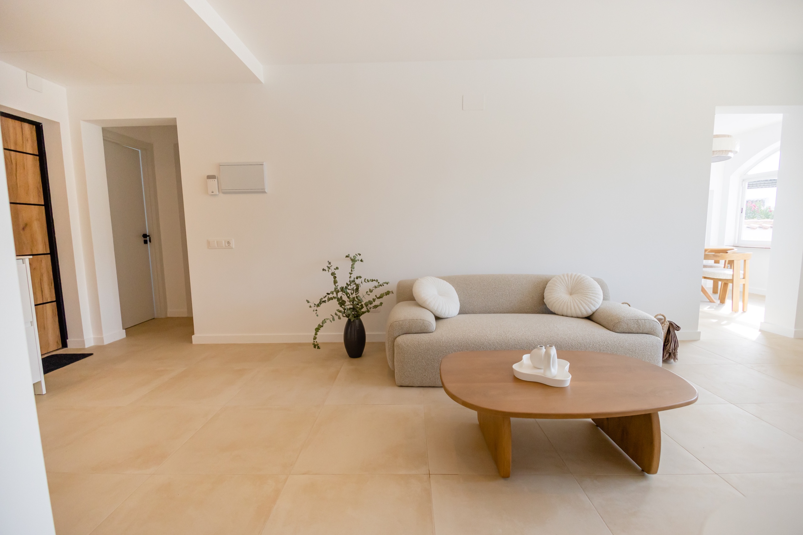Bouclé sofa and oak coffee table on pale stone in the living room