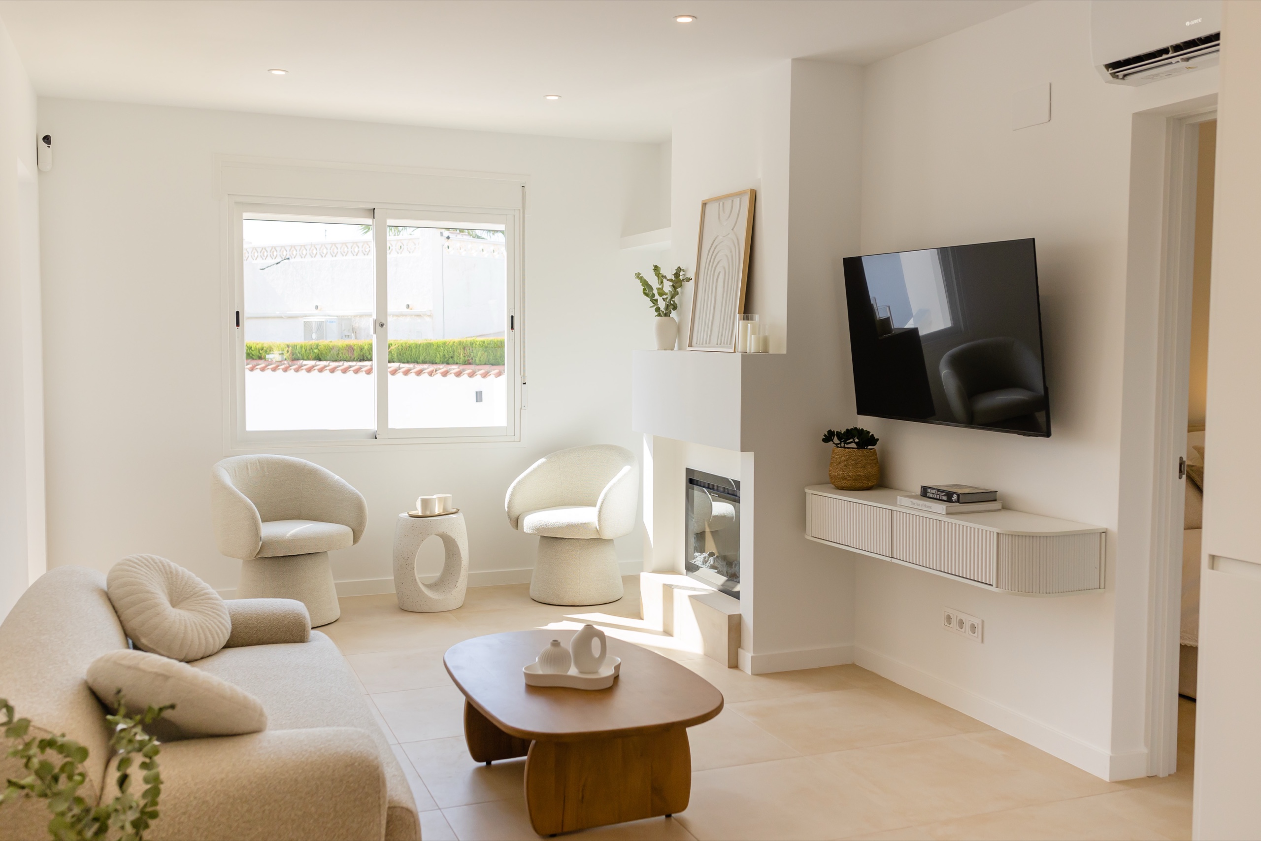 Living room with lounge chairs, fireplace, and a wall-mounted television