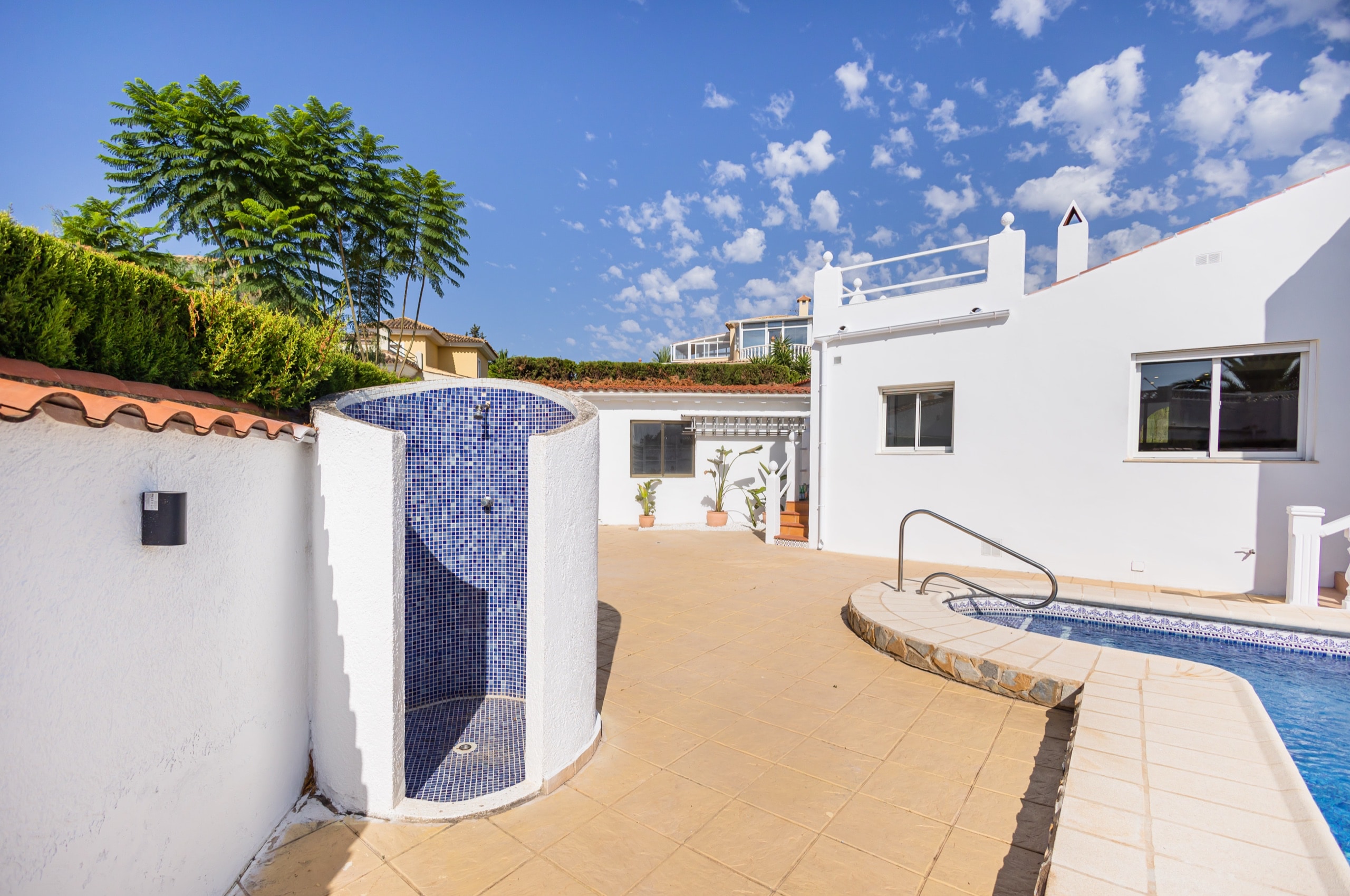 Private pool and outdoor shower in a white courtyard